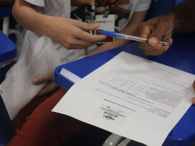 Pessoas segurando uma caneta e um papel