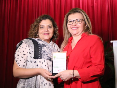 PGJ Carmelina Moura recebe das mãos da Superintendente da SASC, Janaína Mapurunga, a homenagem.