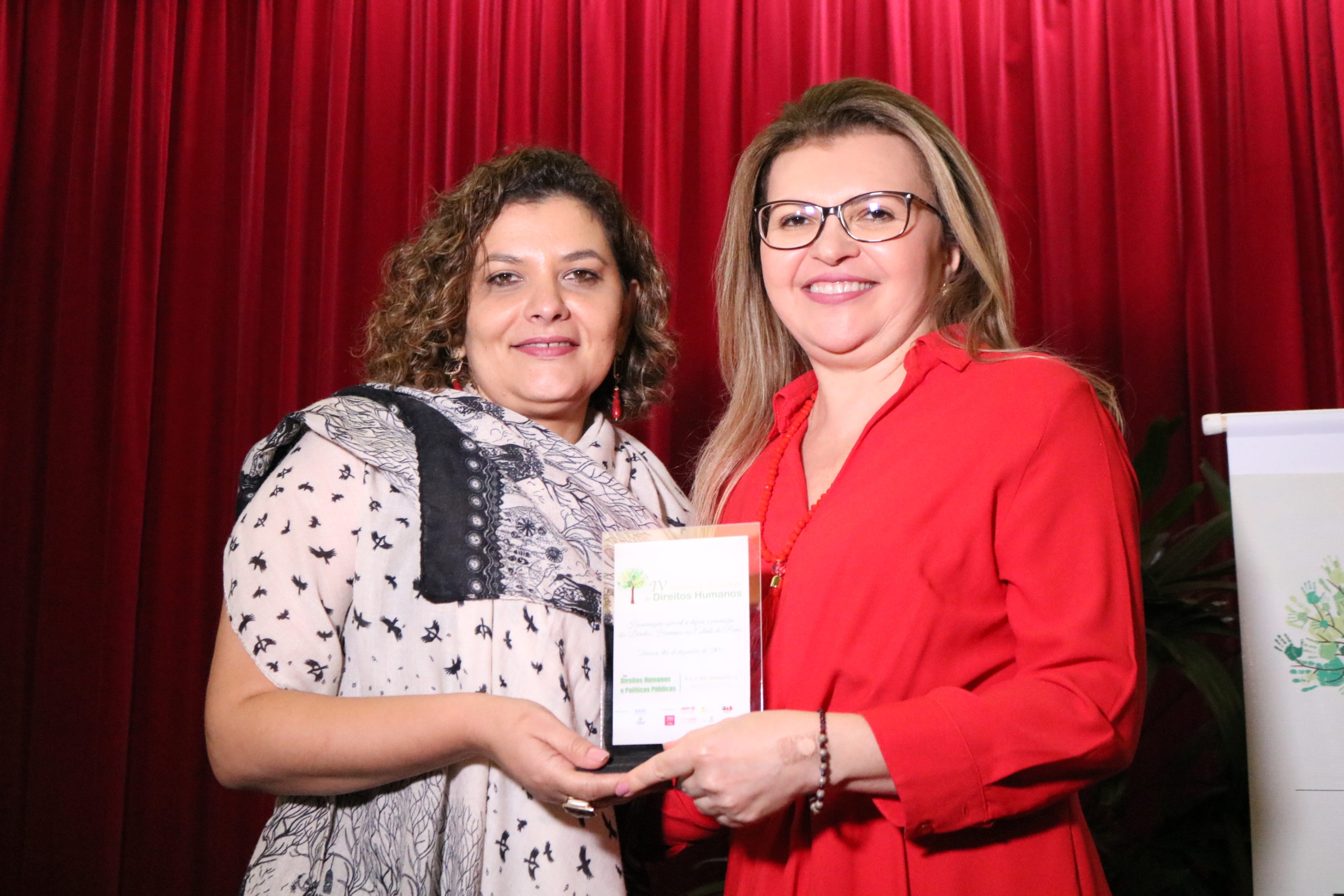 PGJ Carmelina Moura recebe das mãos da Superintendente da SASC, Janaína Mapurunga, a homenagem.