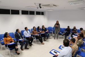 Pessoa em pé falando para pessoas sentadas