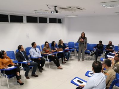 Pessoa em pé falando para pessoas sentadas