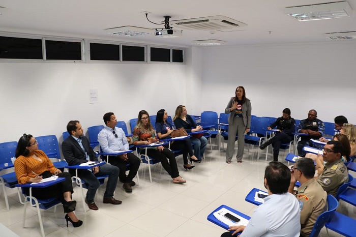 Pessoa em pé falando para pessoas sentadas