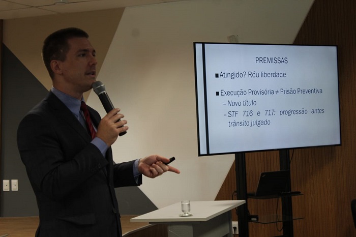 Homem falando diante de plateia