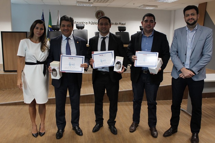 Pessoas reunidas com certificados na mão
