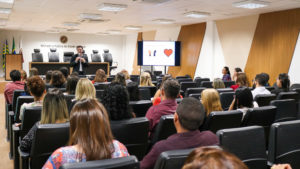 Pessoas observam o palestrante durante evento