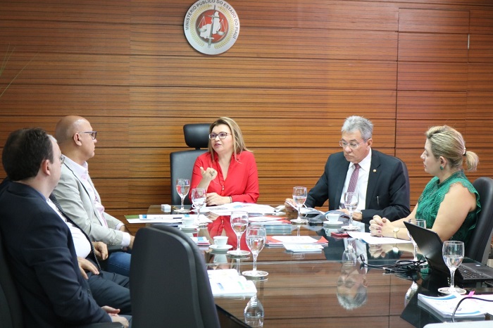 Pessoas reunidas em volta de uma mesa durante reunião