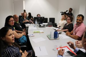 Pessoas reunidas sentadas em torno de uma mesa