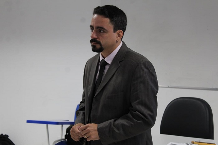 Homem falando diante de plateia 