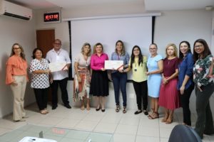 Pessoas reunidas para foto segurando cheque
