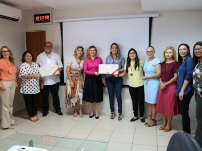 Pessoas reunidas para foto segurando cheque