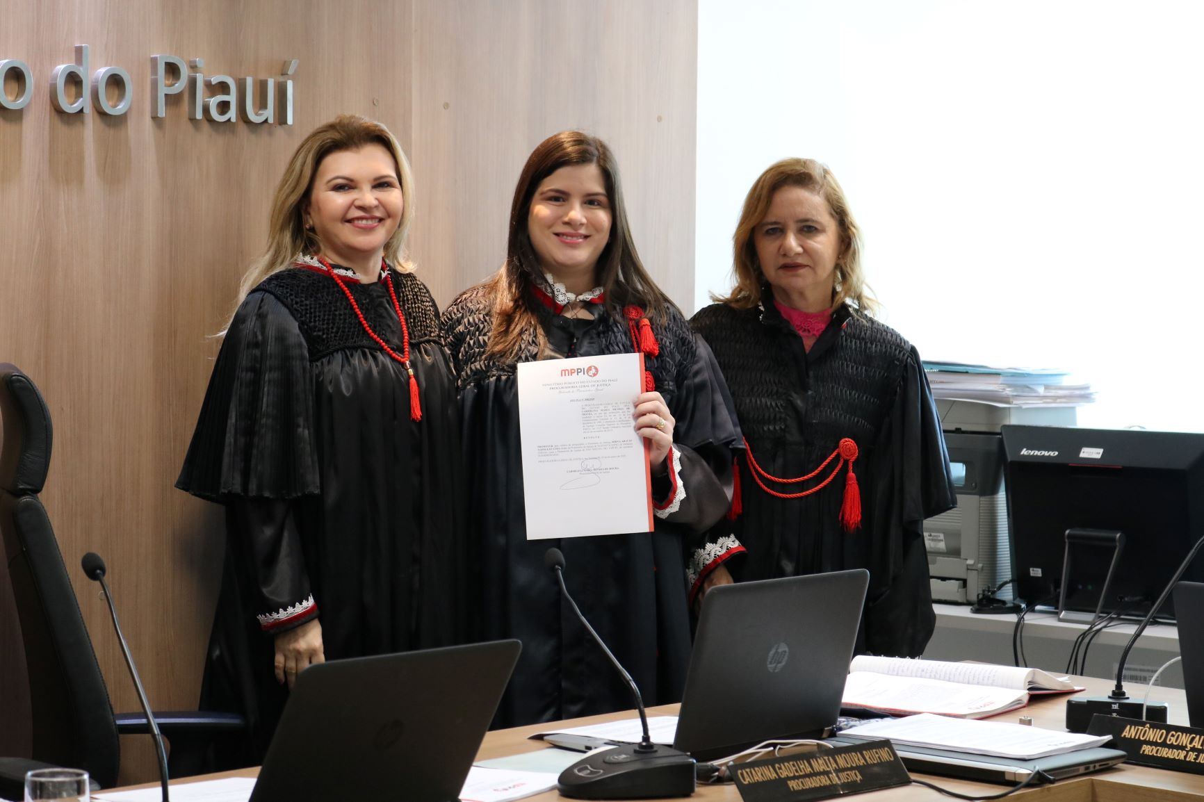 Três mulheres em pé atrás da mesa