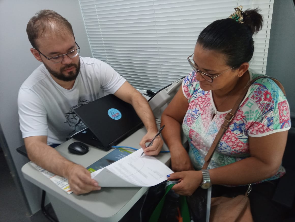Pessoas sendo atendidas por servidores do Procon Itinerante 