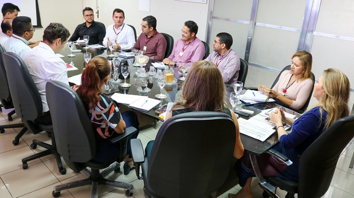 Pessoas sentadas em volta de uma mesa 