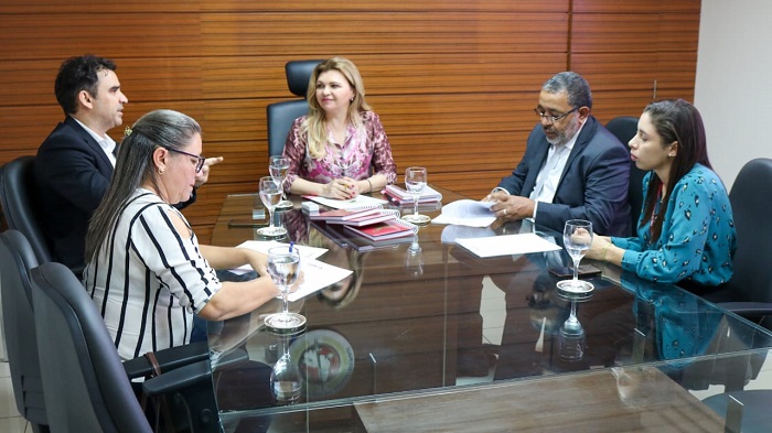 Pessoas sentadas em volta de uma mesa 