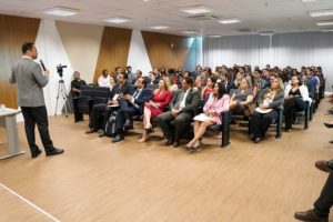 Pessoas sentadas em auditório assistindo palestra