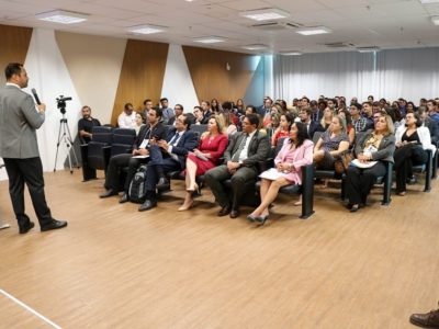 Pessoas sentadas em auditório assistindo palestra
