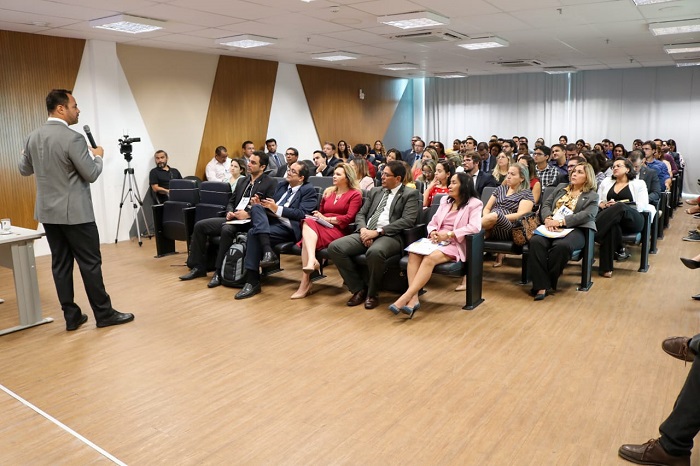 Pessoas sentadas em auditório assistindo palestra