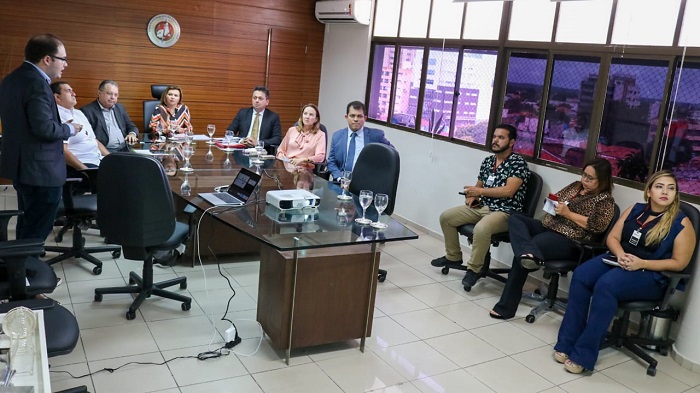 Pessoas sentadas em volta de uma mesa de reunião