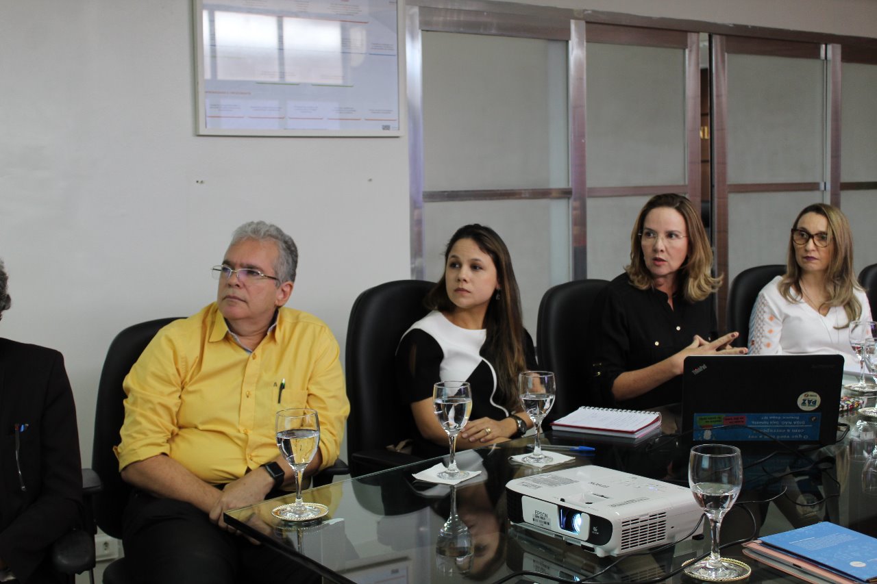 Pessoas sentadas em volta de uma mesa 