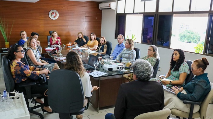 Pessoas sentadas em volta de uma mesa