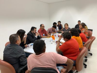 Pessoas sentadas em volta de uma mesa