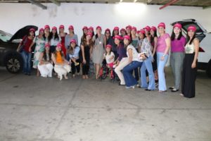 mulheres usando boné rosa posando para foto