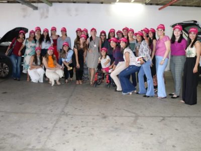 mulheres usando boné rosa posando para foto