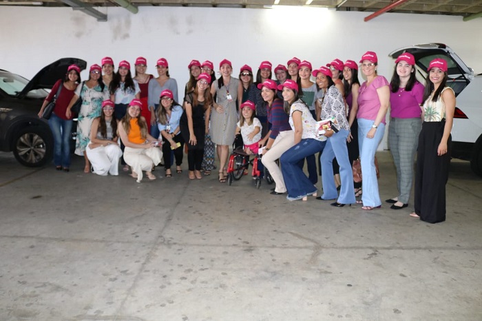 mulheres usando boné rosa posando para foto