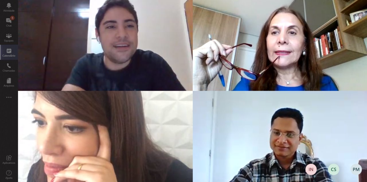 Tela com quatro pessoas reunidas 