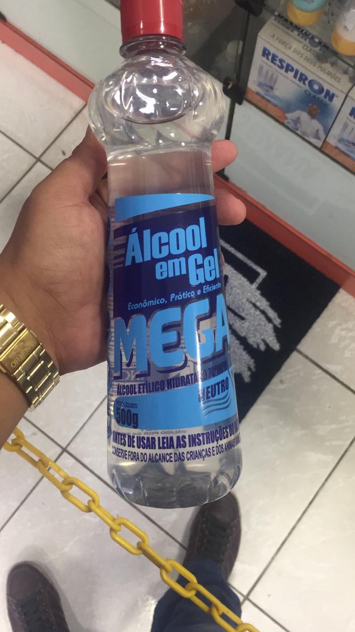 Pessoa segurando um vidro de álcool gel 