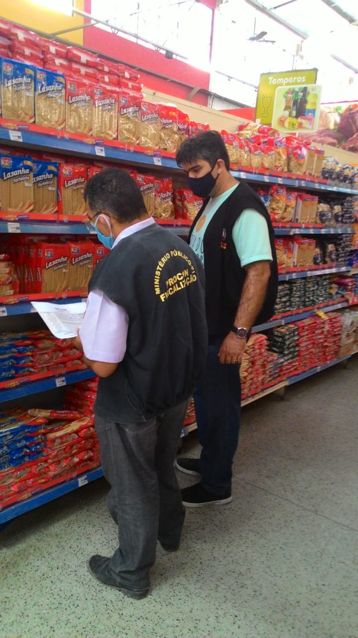 Duas pessoas de pé verificando o preço de produtos 