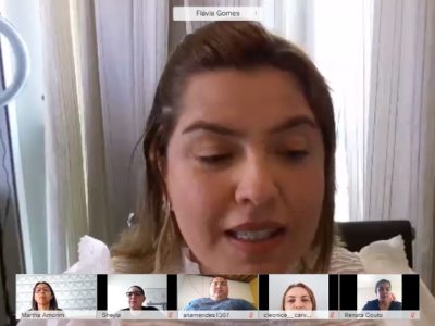Promotora de Justiça Flávia Gomes durante reunião virtual. Na parte inferior da imagem, pessoas observam a fala dela